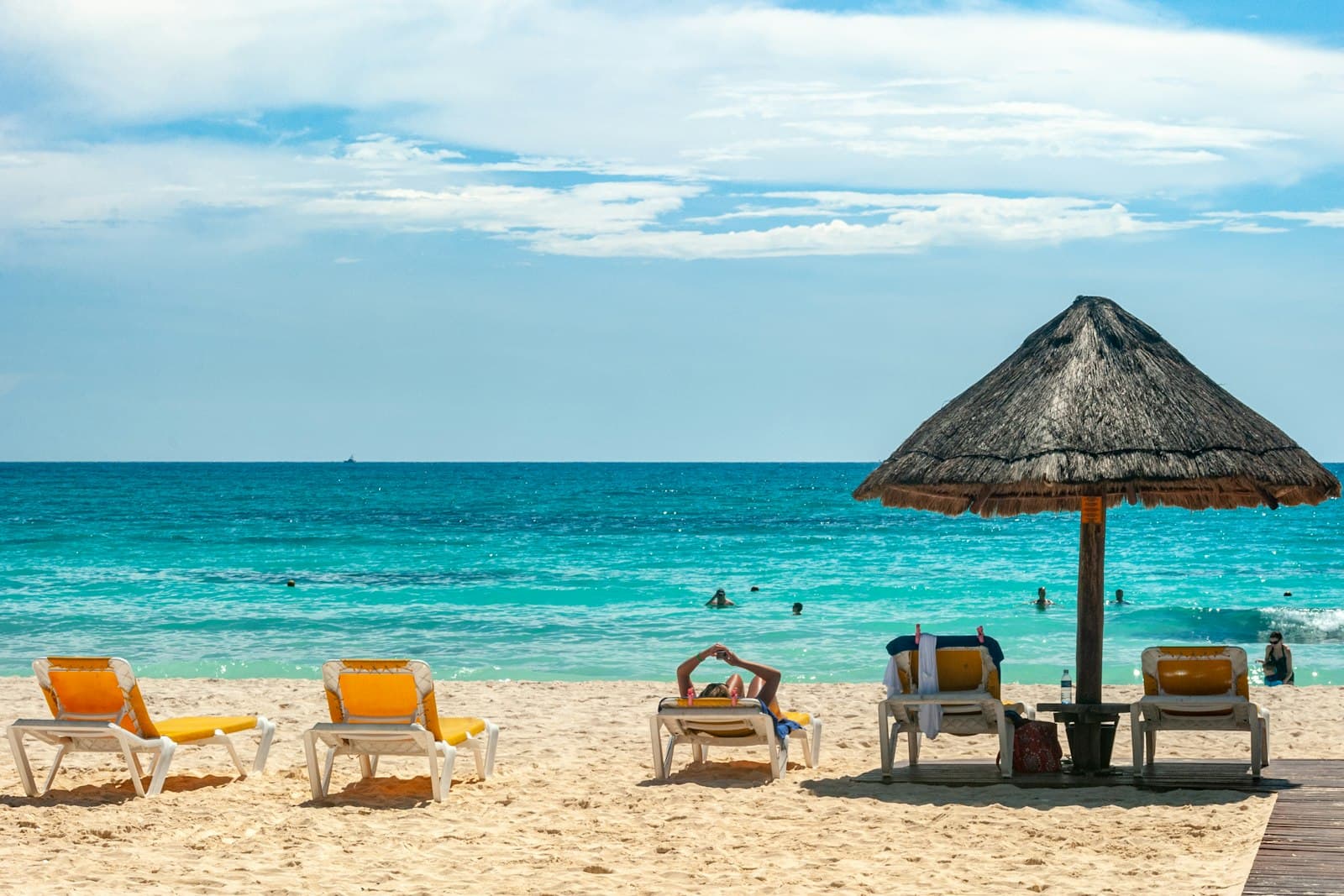 Mer turquoise et parasol en palapa sur une plage de Cancún